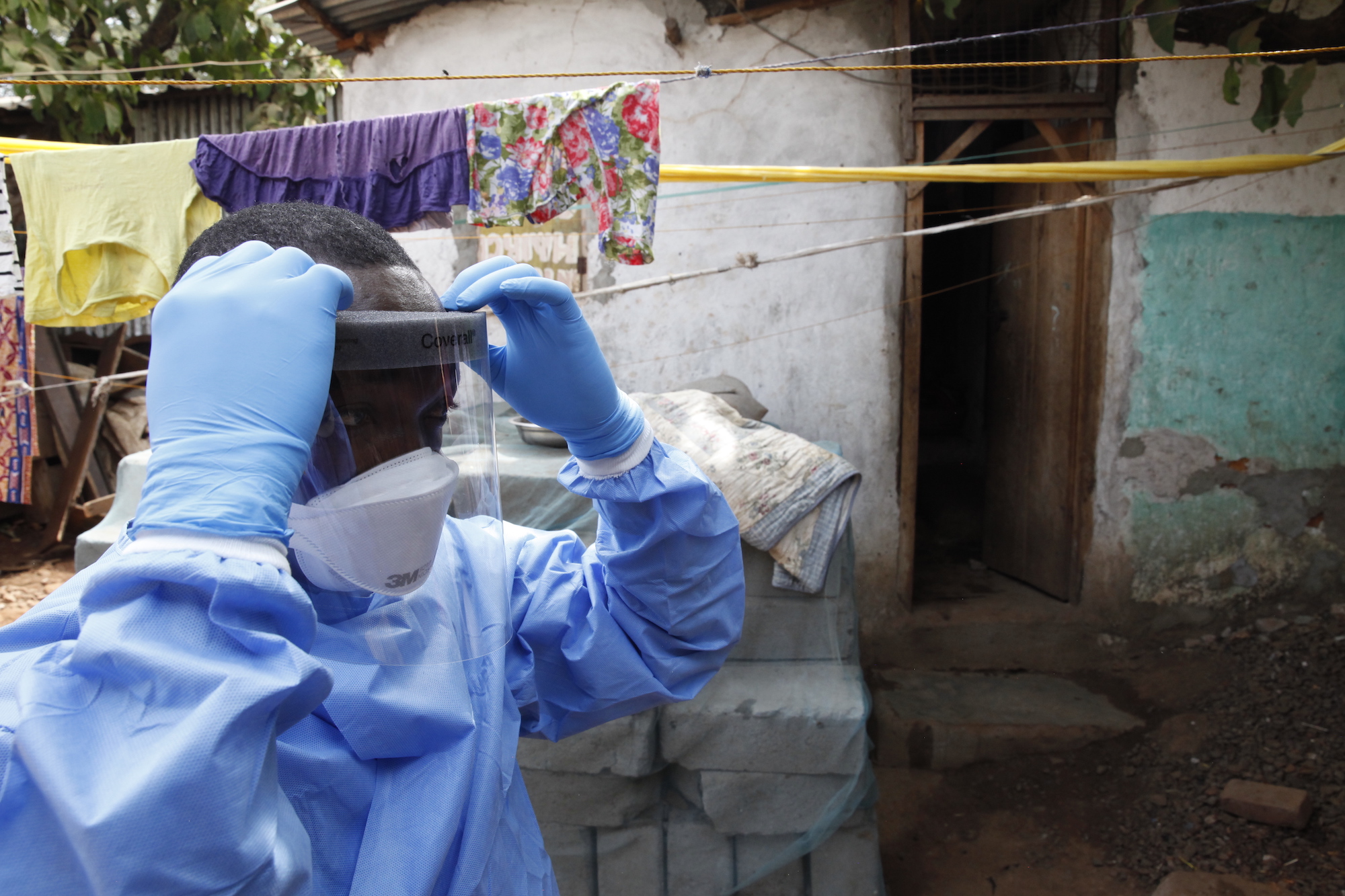 シエラレオネのエボラ流行時、死亡した新生児のサンプル採取のために防護服を着用する様子
